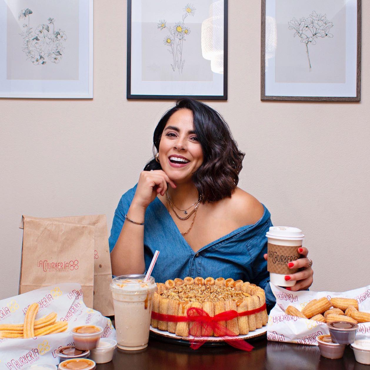 A joyful La Churrería guest surrounded by churros, coffee, and house specialties